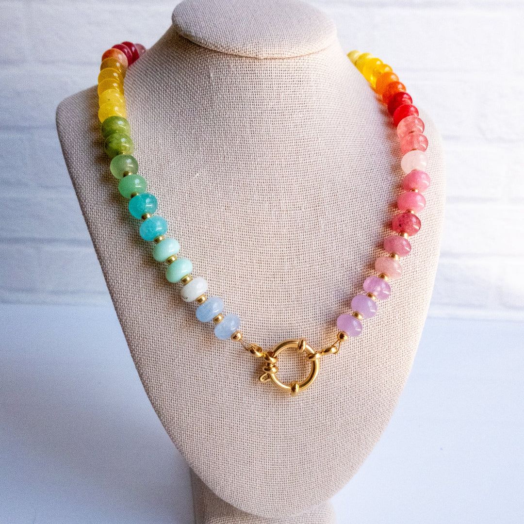 Colorful beaded necklace on a beige mannequin bust with a white background