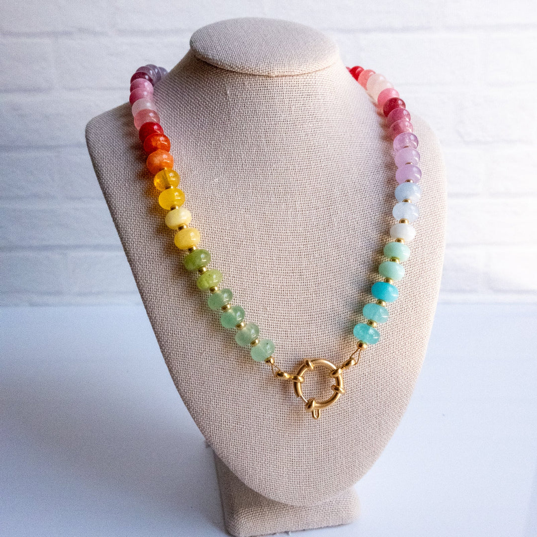 Necklace with multicolored beads on a beige bust against a white background