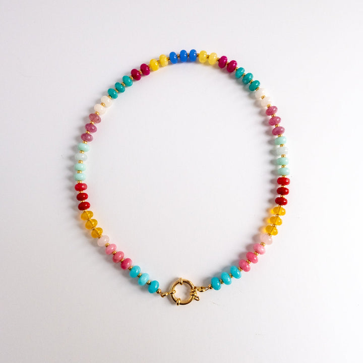 Colorful beaded necklace with a gold clasp on a light gray background