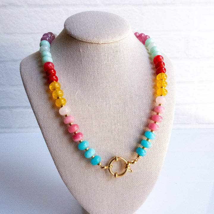 Colorful beaded necklace on a beige bust against a white background