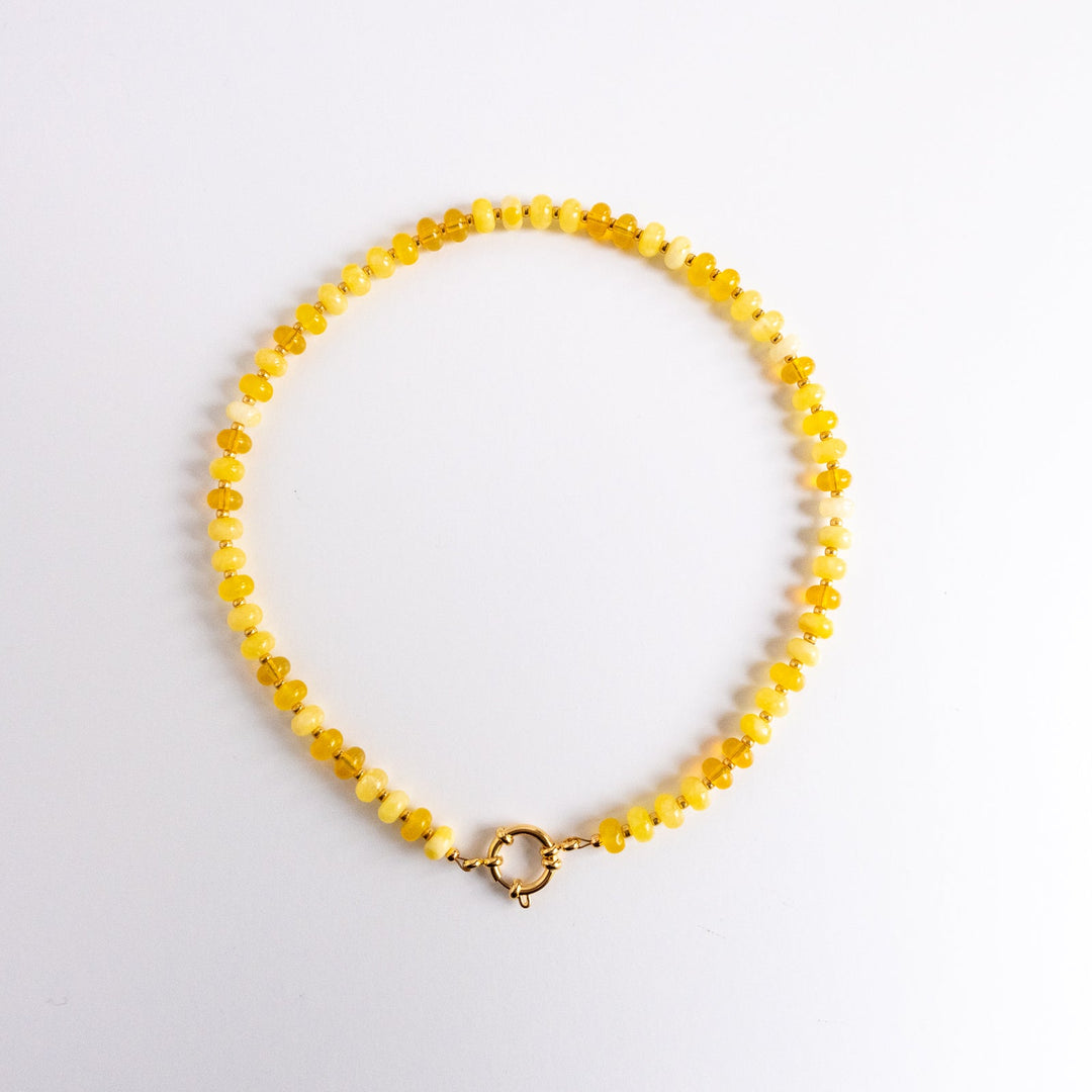Yellow beaded necklace on a white background