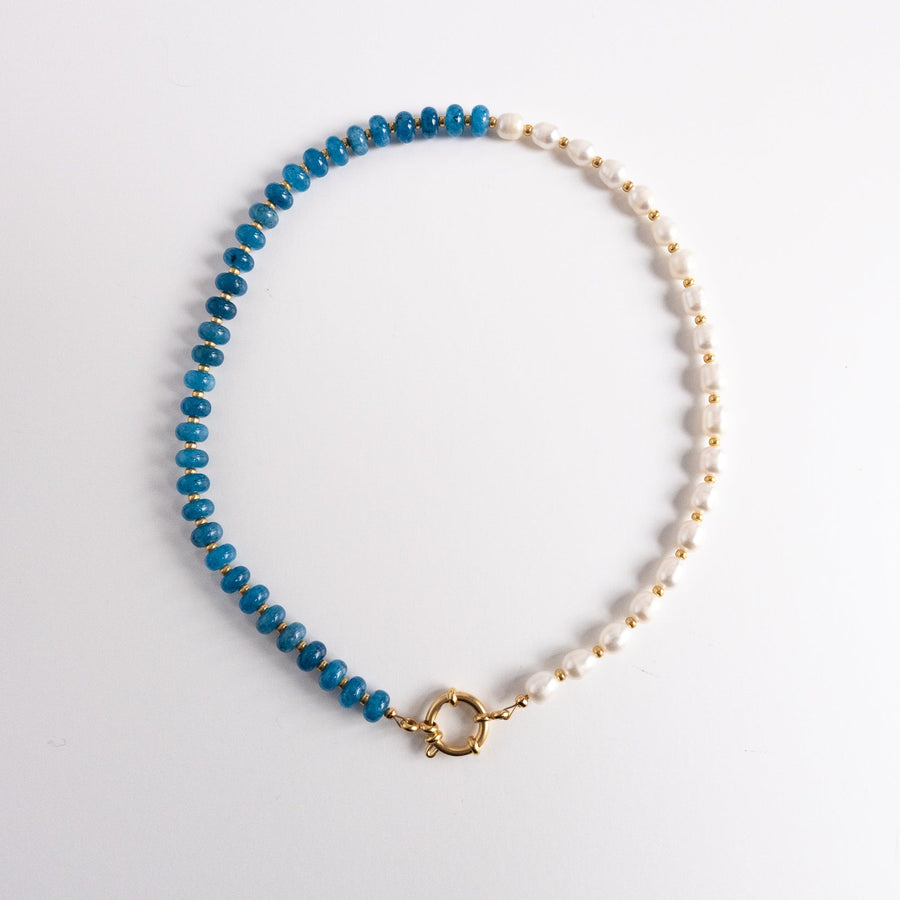 Necklace with blue beads and gold clasp on a white background