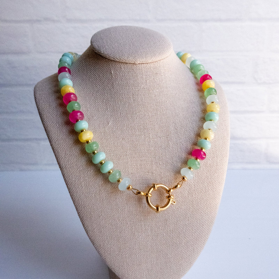 Colorful beaded necklace on a beige mannequin bust against a white background