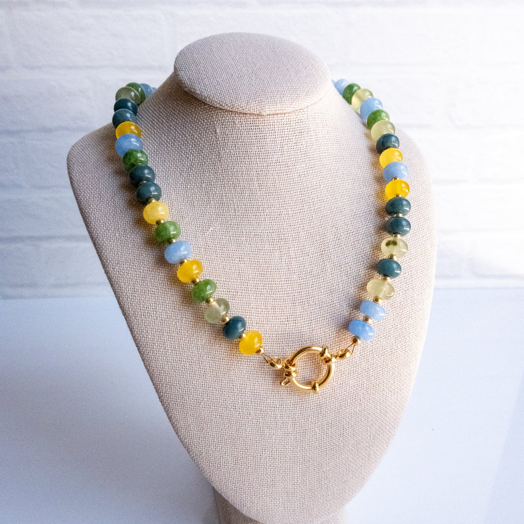 Necklace with multicolored beads on a beige bust against a white background
