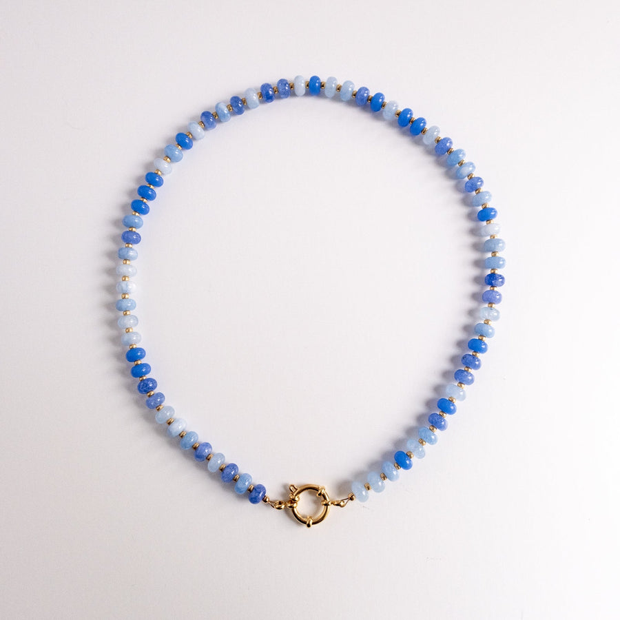 Beaded necklace with blue and gray stones on a white background