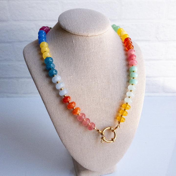 Colorful beaded necklace on a beige bust against a white background