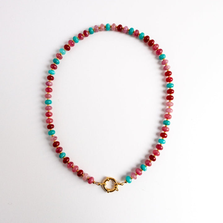 Beaded necklace with red and turquoise beads on a white background
