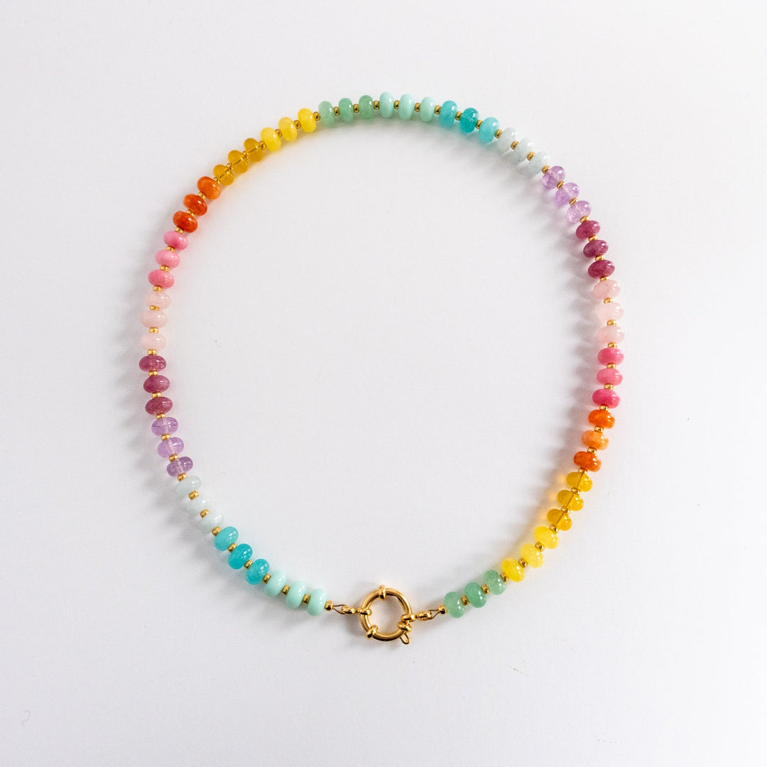 Multicolored beaded necklace with a gold clasp on a light gray background
