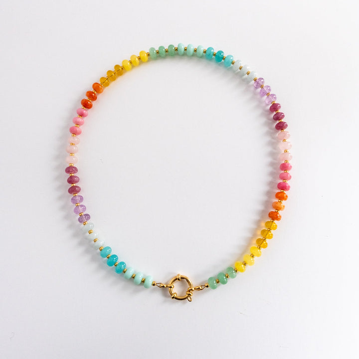 Multicolored beaded necklace with a gold clasp on a light gray background
